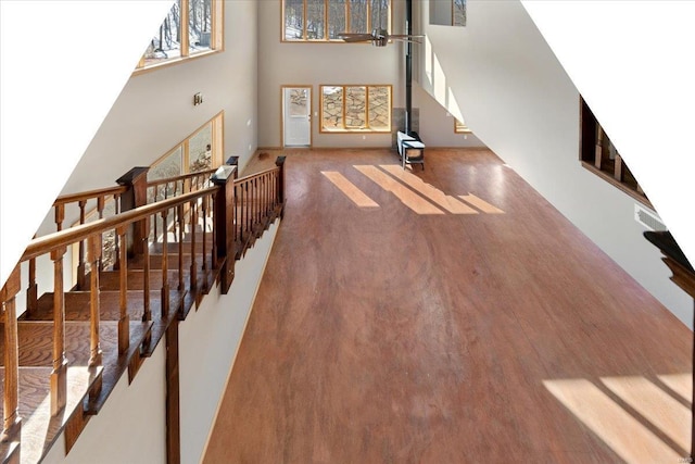 living room featuring hardwood / wood-style floors, a wood stove, and a high ceiling