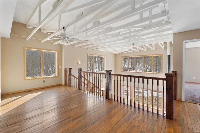 unfurnished room with vaulted ceiling with beams, hardwood / wood-style floors, and ceiling fan