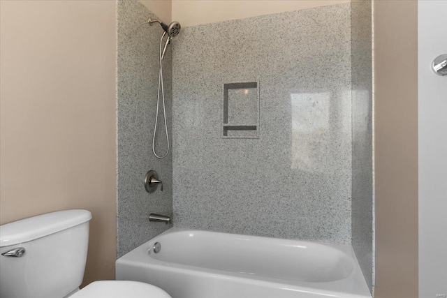 bathroom featuring tiled shower / bath and toilet