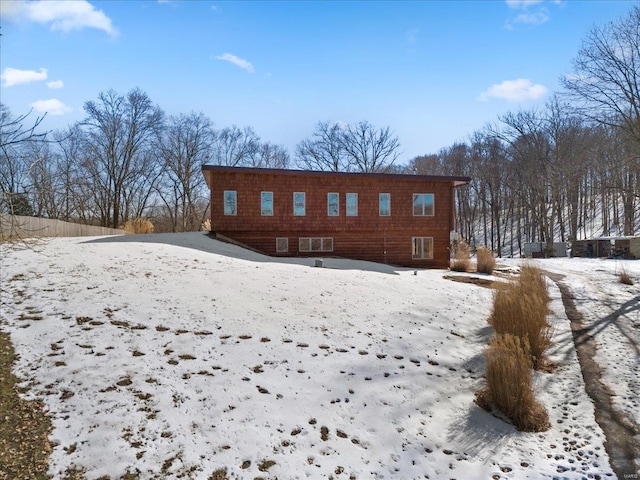 view of snow covered back of property