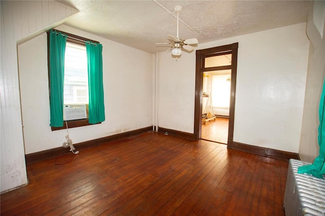 empty room featuring a textured ceiling, ceiling fan, cooling unit, and dark wood-type flooring