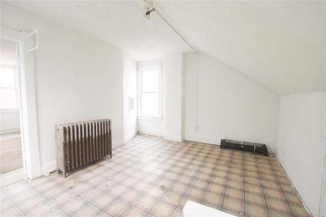 additional living space featuring radiator and lofted ceiling