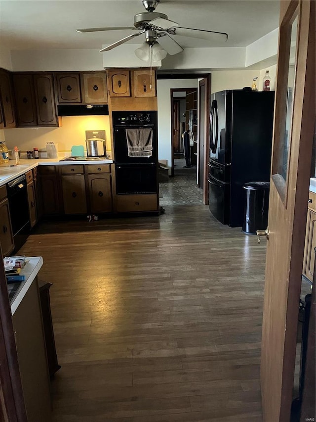 kitchen featuring ceiling fan, dark wood-type flooring, black appliances, and dark brown cabinets