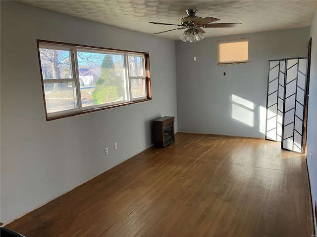 unfurnished room featuring wood-type flooring, a textured ceiling, and ceiling fan