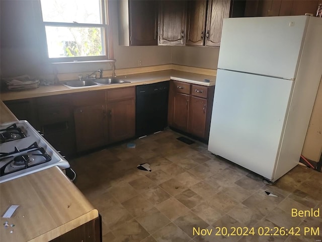 kitchen with dishwasher, white fridge, dark brown cabinetry, and sink