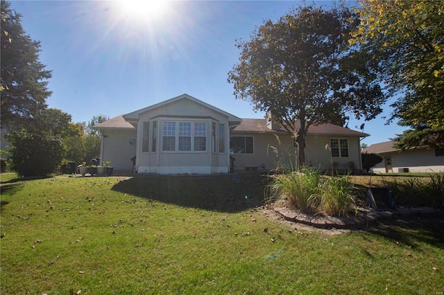 rear view of property with a lawn