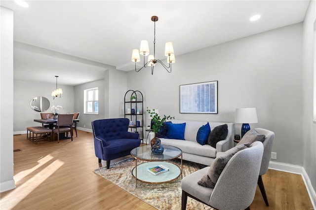 living room with a chandelier, recessed lighting, baseboards, and light wood-style floors