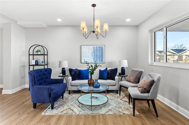 living area featuring light wood-style floors, baseboards, a notable chandelier, and recessed lighting