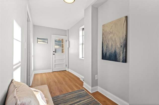 entryway featuring visible vents, baseboards, and wood finished floors