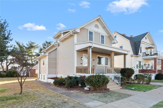 view of property with covered porch and a front yard