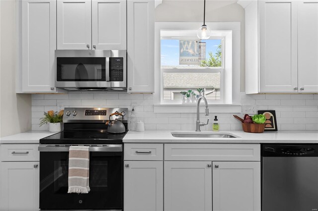 kitchen featuring appliances with stainless steel finishes, white cabinetry, and a sink
