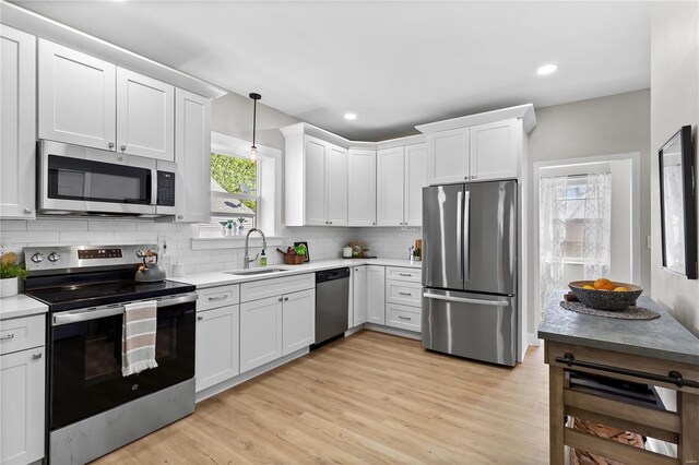 kitchen with white cabinets, tasteful backsplash, appliances with stainless steel finishes, and a sink