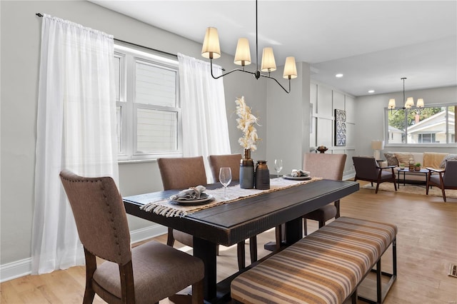 dining area featuring light wood-style flooring, baseboards, an inviting chandelier, and recessed lighting