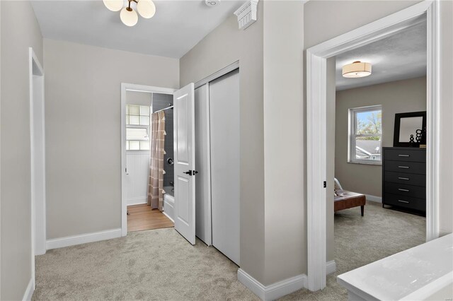 corridor with baseboards and carpet floors