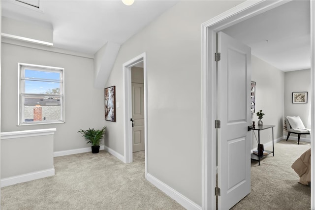 hall featuring light carpet and baseboards