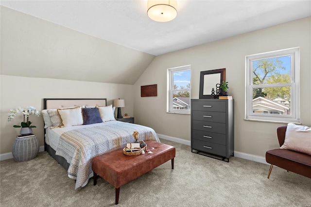 bedroom featuring light carpet, lofted ceiling, and baseboards