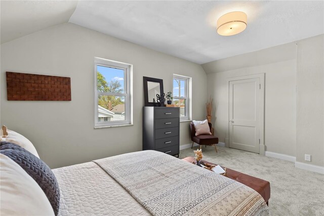 bedroom with lofted ceiling, baseboards, and light colored carpet