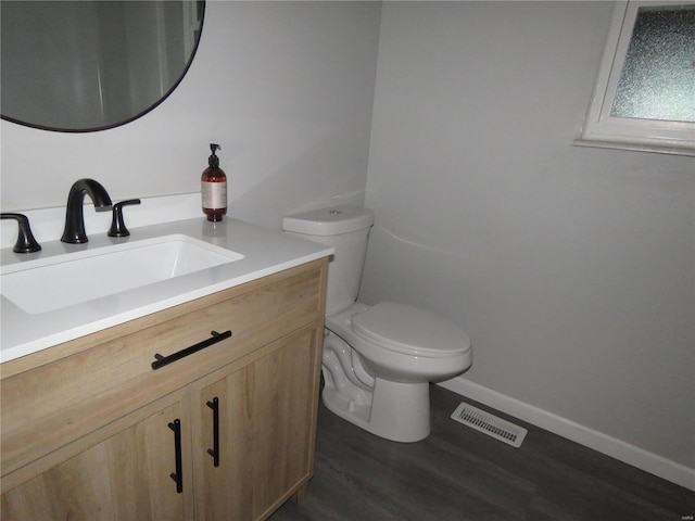 bathroom featuring wood-type flooring, vanity, and toilet