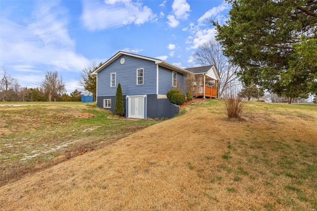 view of side of home featuring a lawn and a wooden deck