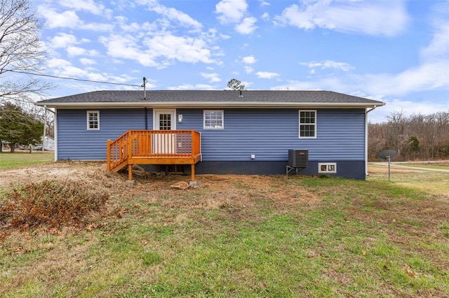 back of property with central AC unit and a yard