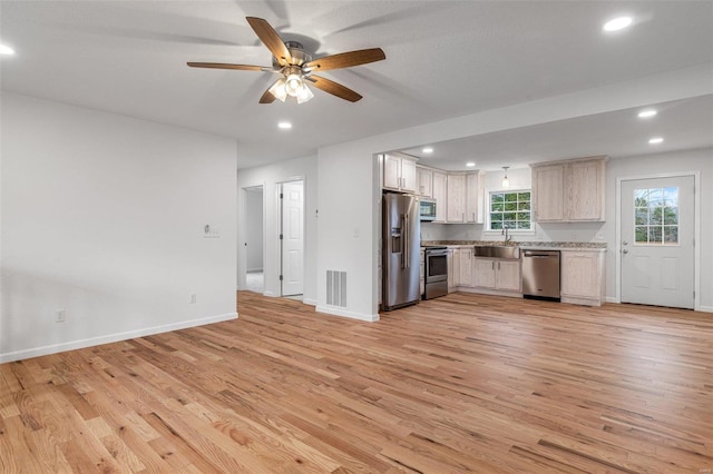 kitchen featuring ceiling fan, light wood-type flooring, sink, and appliances with stainless steel finishes