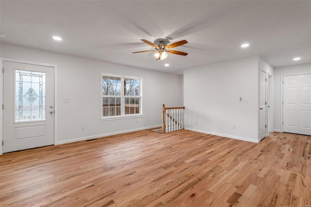 foyer entrance featuring ceiling fan, light wood-type flooring, and a textured ceiling