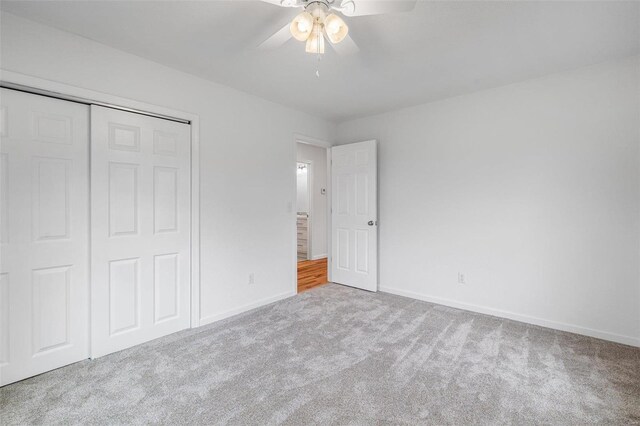 unfurnished bedroom featuring a closet, light colored carpet, and ceiling fan