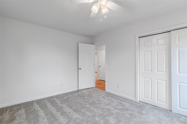 unfurnished bedroom with ceiling fan, a closet, and light colored carpet