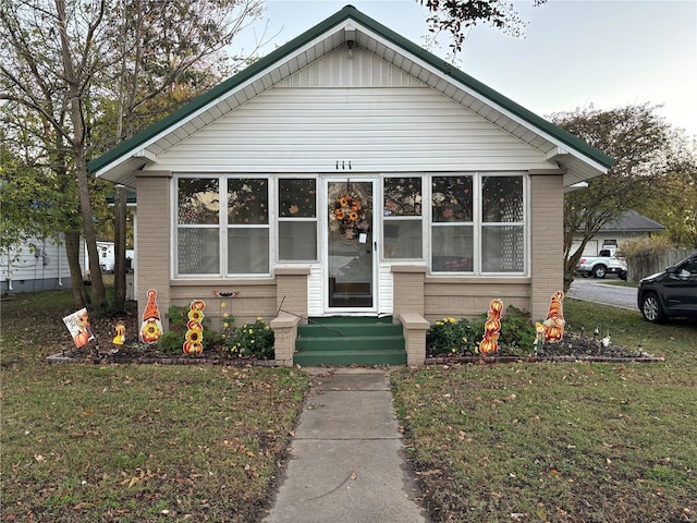 bungalow-style house with a front lawn