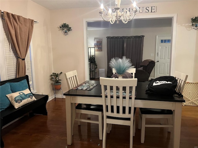 dining room with dark hardwood / wood-style flooring and a notable chandelier