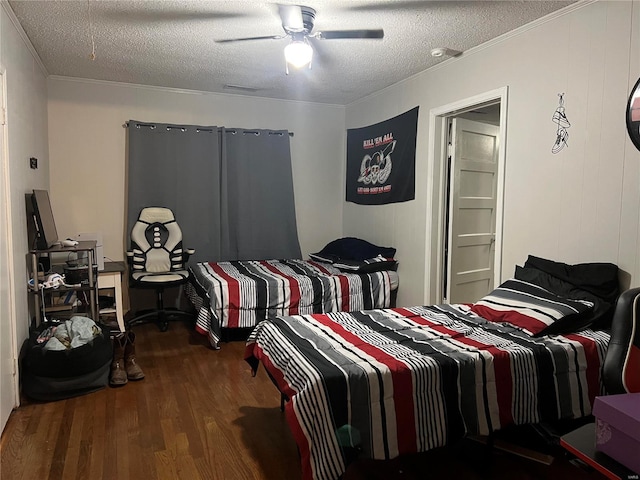 bedroom with dark hardwood / wood-style flooring, a textured ceiling, ceiling fan, and ornamental molding