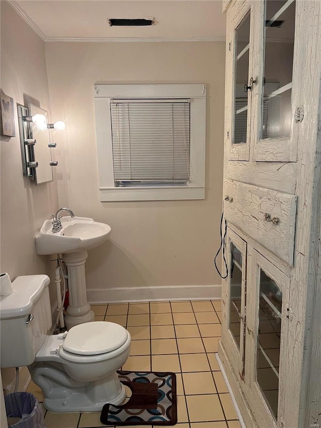 bathroom with tile patterned flooring, toilet, and ornamental molding