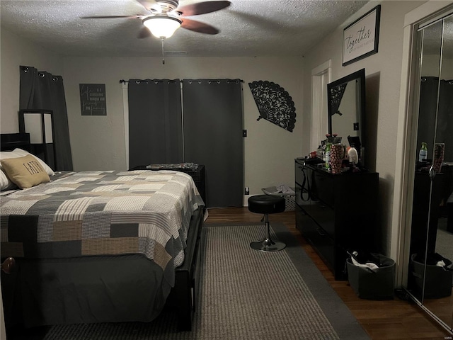 bedroom featuring a textured ceiling, ceiling fan, and dark wood-type flooring