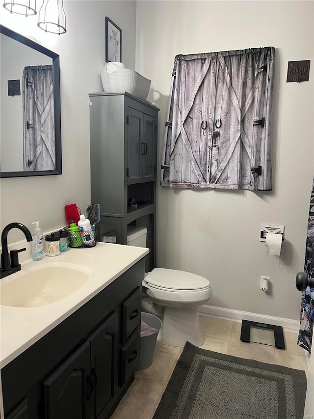 bathroom with tile patterned flooring, vanity, and toilet