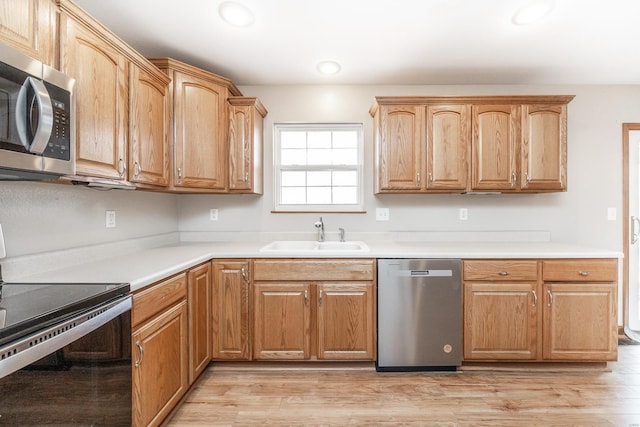 kitchen featuring appliances with stainless steel finishes, light wood-type flooring, and sink