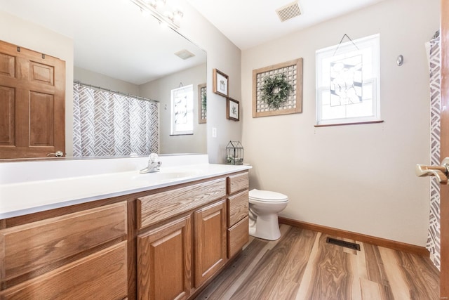 bathroom with toilet, vanity, and hardwood / wood-style floors