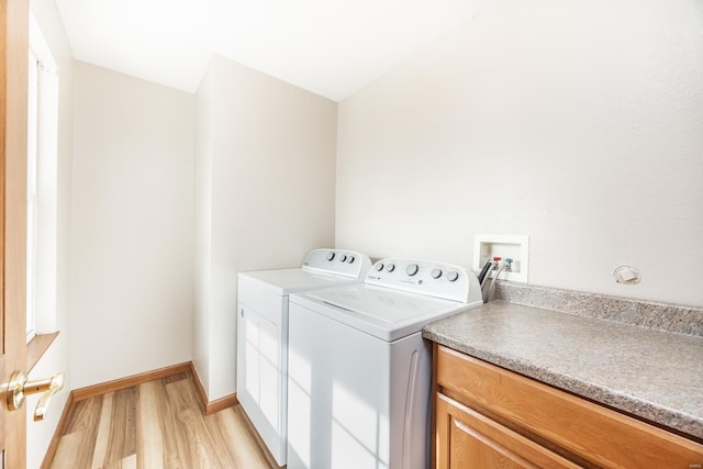 clothes washing area with light wood-type flooring and washing machine and dryer