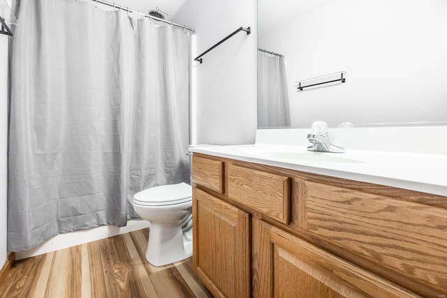 bathroom featuring toilet, vanity, and hardwood / wood-style flooring