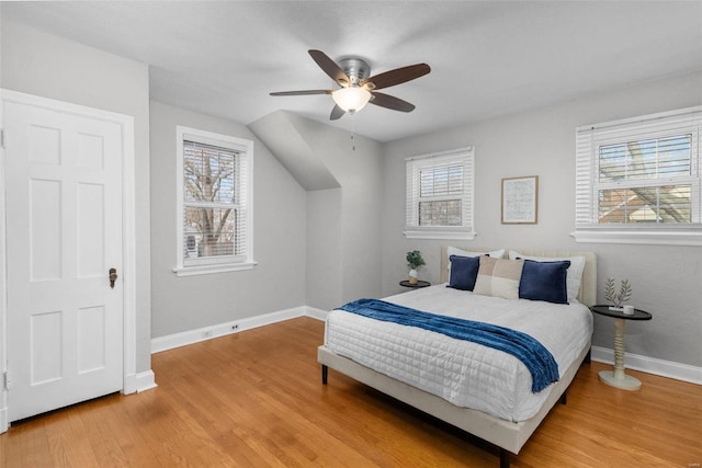 bedroom with hardwood / wood-style flooring, ceiling fan, and multiple windows