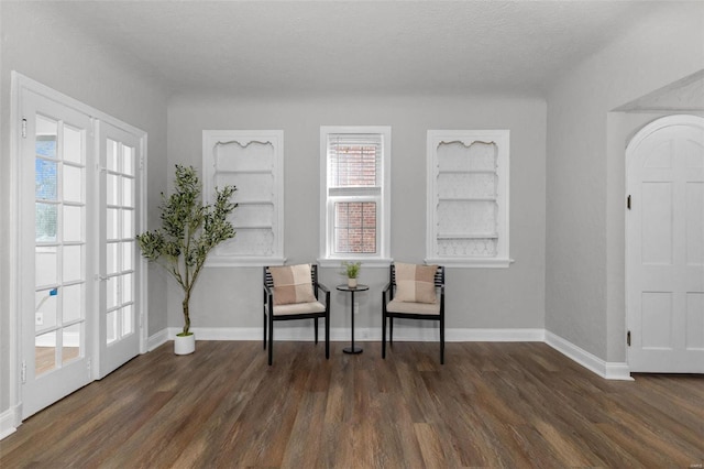 living area featuring a textured ceiling, a wealth of natural light, and dark wood-type flooring