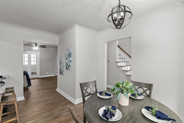 dining area featuring ceiling fan with notable chandelier, dark wood-type flooring, and a textured ceiling