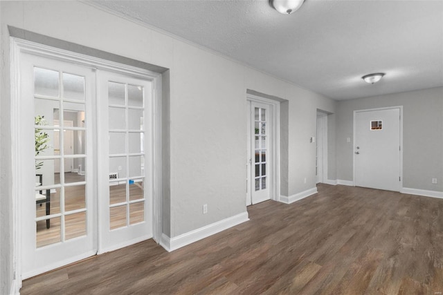 entrance foyer with a textured ceiling, dark hardwood / wood-style flooring, and french doors