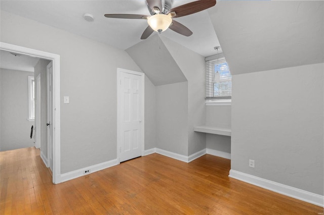 additional living space with vaulted ceiling, light hardwood / wood-style flooring, and ceiling fan