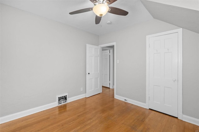 unfurnished bedroom featuring ceiling fan, wood-type flooring, and vaulted ceiling