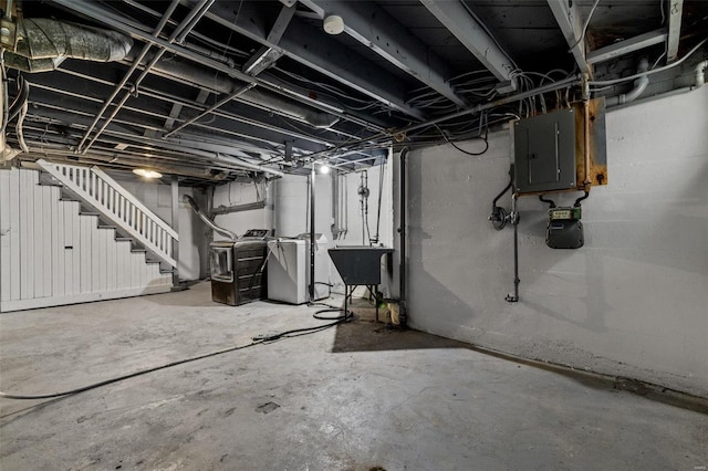 basement with washer and clothes dryer, electric panel, and sink