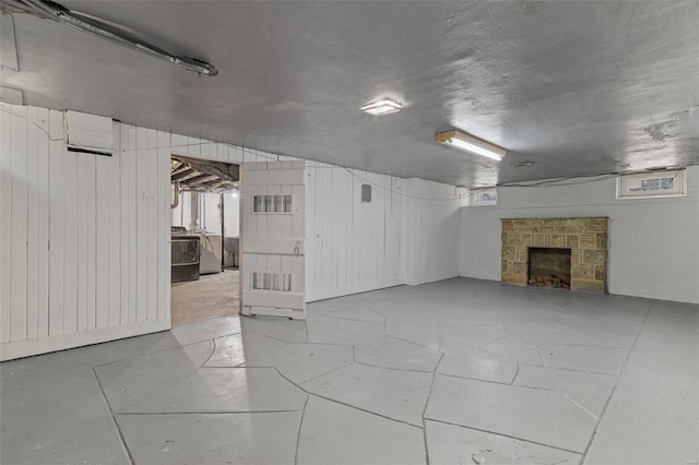 basement with wooden walls, a fireplace, and washer / clothes dryer