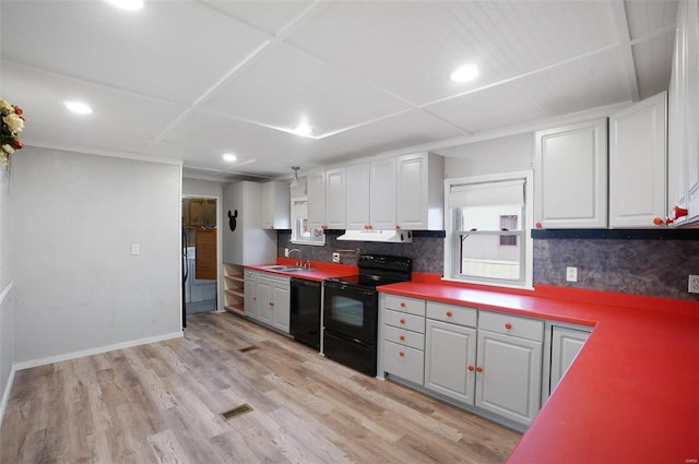 kitchen with backsplash, black appliances, white cabinets, sink, and light hardwood / wood-style floors