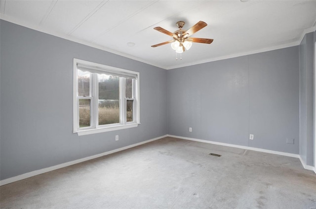 carpeted spare room with ceiling fan and crown molding