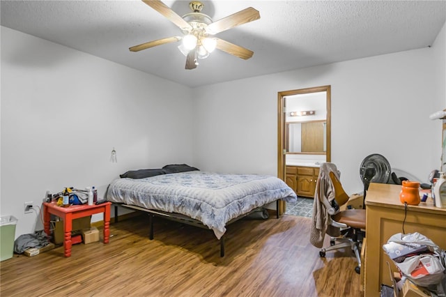 bedroom featuring ceiling fan, hardwood / wood-style floors, a textured ceiling, and connected bathroom