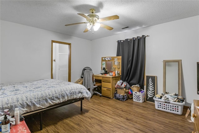 bedroom featuring a textured ceiling, ceiling fan, and hardwood / wood-style flooring